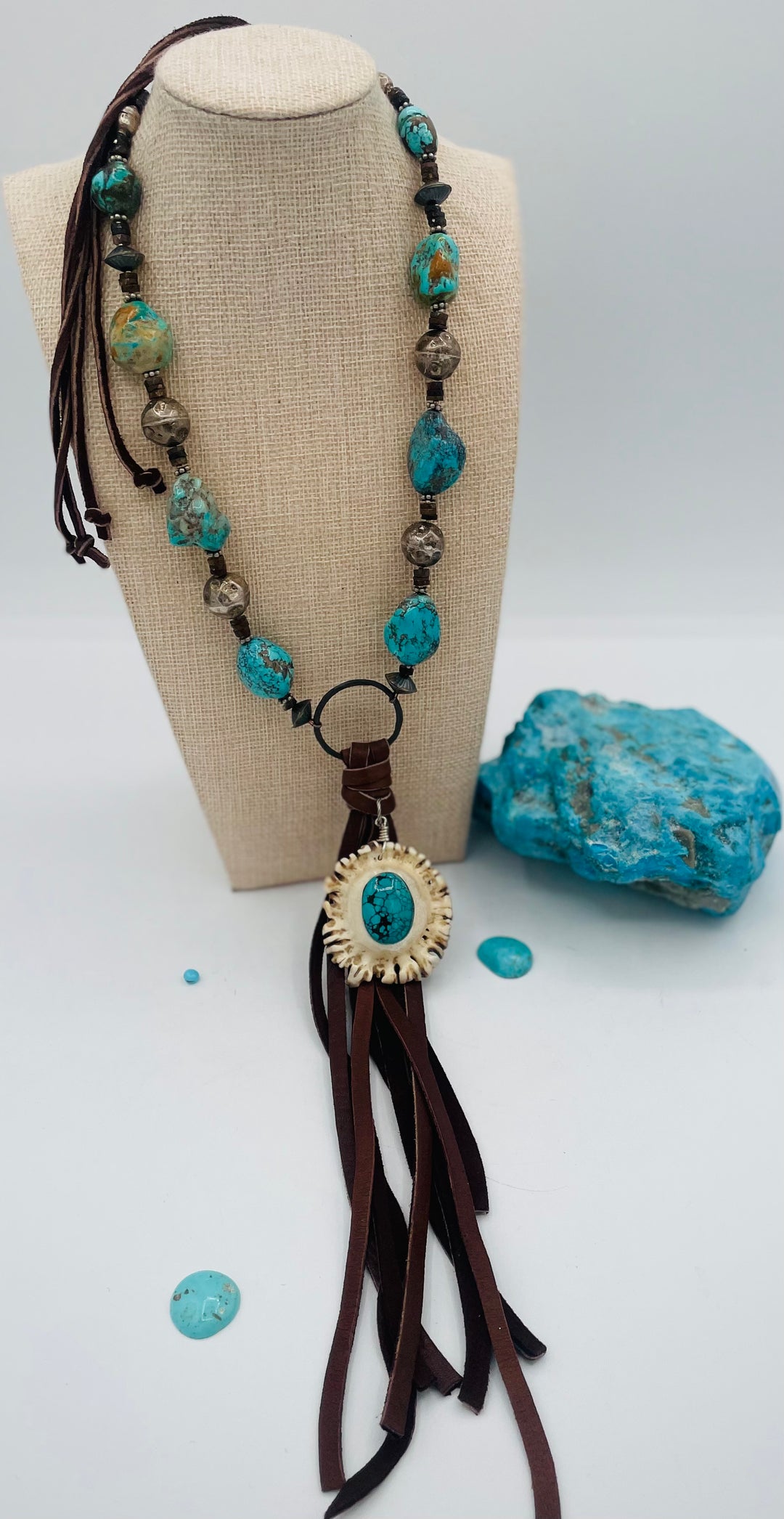 Adjustable beaded necklace featuring Kingman turquoise, hessonite garnet, vintage sterling silver, deer lace tassel with deer antler pendent, and finished with deer lace in the back. Available only from Rockstar Cowgirl online or in store in Cody, Wyoming.