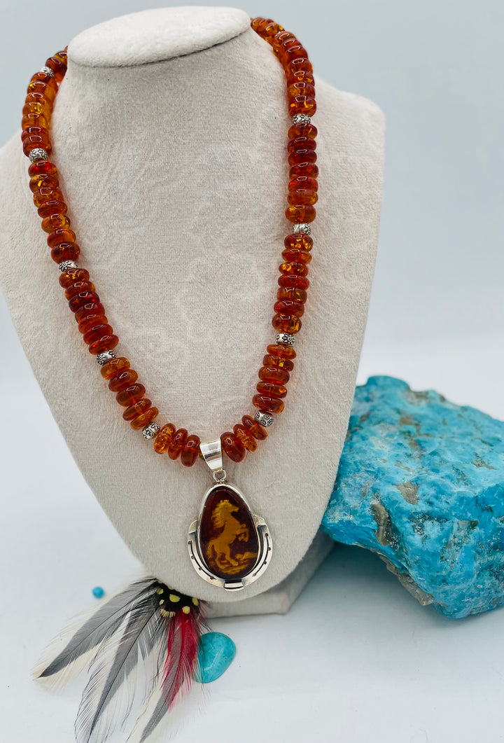 Beaded Baltic amber and sterling silver necklace featuring a Baltic amber and sterling silver pendent with a carved horse reverse cameo. Available only from Rockstar Cowgirl online or in store in Cody, Wyoming.