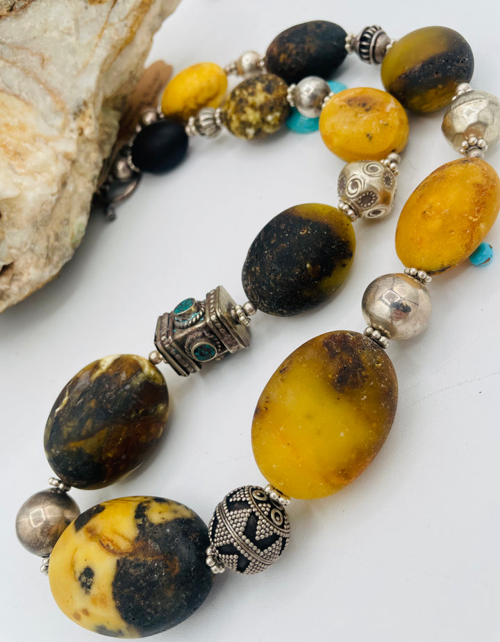 Chunky beaded necklace featuring Baltic amber, repousse beads with turquoise inlay, and sterling silver beads. Available only from Rockstar Cowgirl online or in store in Cody, Wyoming.