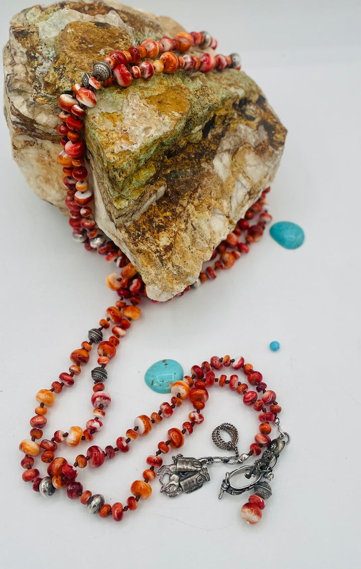 Silk knotted lariat necklace featuring spiney oyster, sterling silver stamped beads, and vintage sterling silver western charms. Available only from Rockstar Cowgirl online or in store in Cody, Wyoming. 
