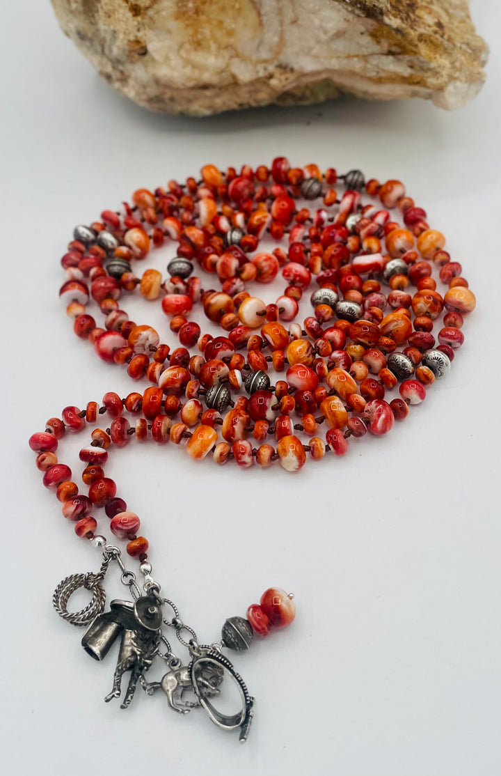 Silk knotted lariat necklace featuring spiney oyster, sterling silver stamped beads, and vintage sterling silver western charms. Available only from Rockstar Cowgirl online or in store in Cody, Wyoming. 