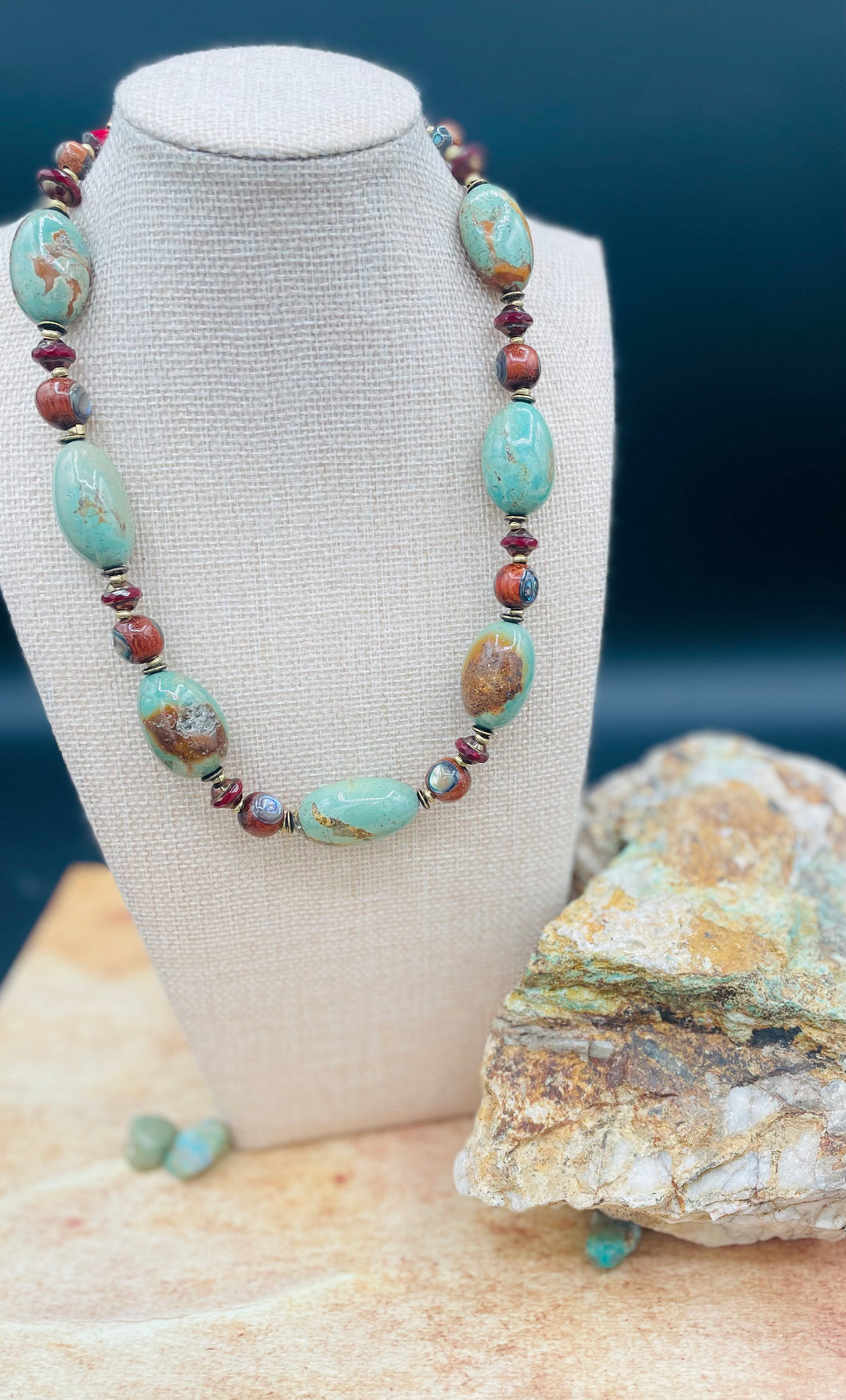 This necklace features large green Kingman turquoise smooth nuggets, abalone inlaid wood beads, and red travertine Czech beads. Available only from Rockstar Cowgirl online or in store in Cody, Wyoming. 