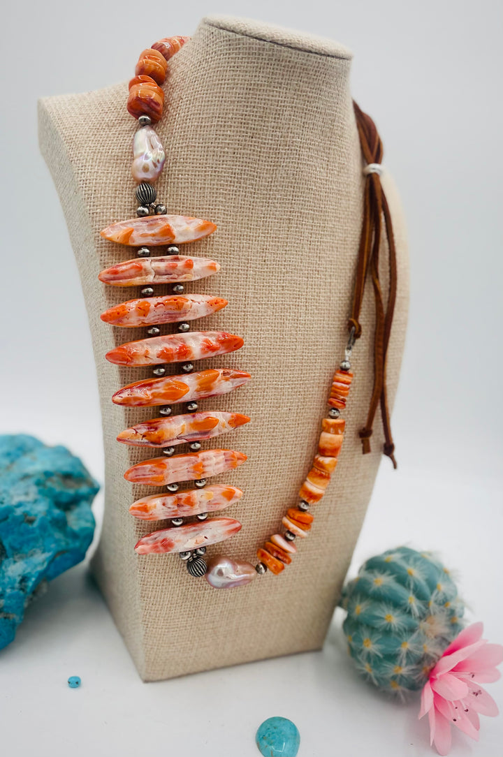Adjustable beaded hatband featuring spiney oyster, natural luster flameball pearls, sterling silver beads, and finished with deer lace in the back. Available only from Rockstar Cowgirl online or in store in Cody, Wyoming.