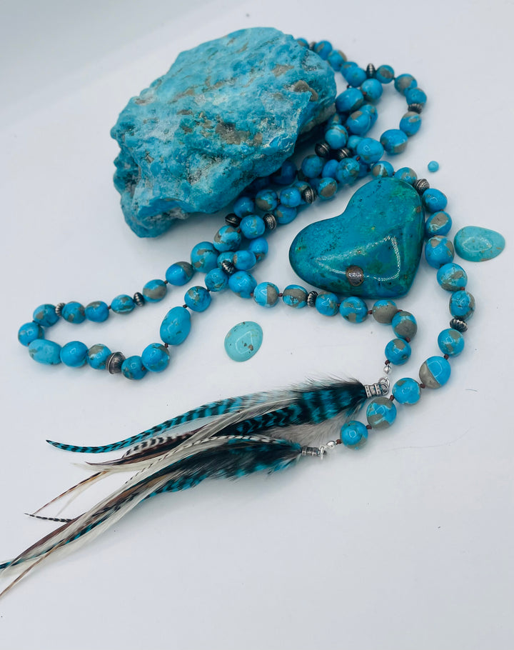 Silk knotted lariat featuring Ithaca peak turquoise, sterling silver beads, and feather tassels. Available only from Rockstar Cowgirl online or in store in Cody, Wyoming.