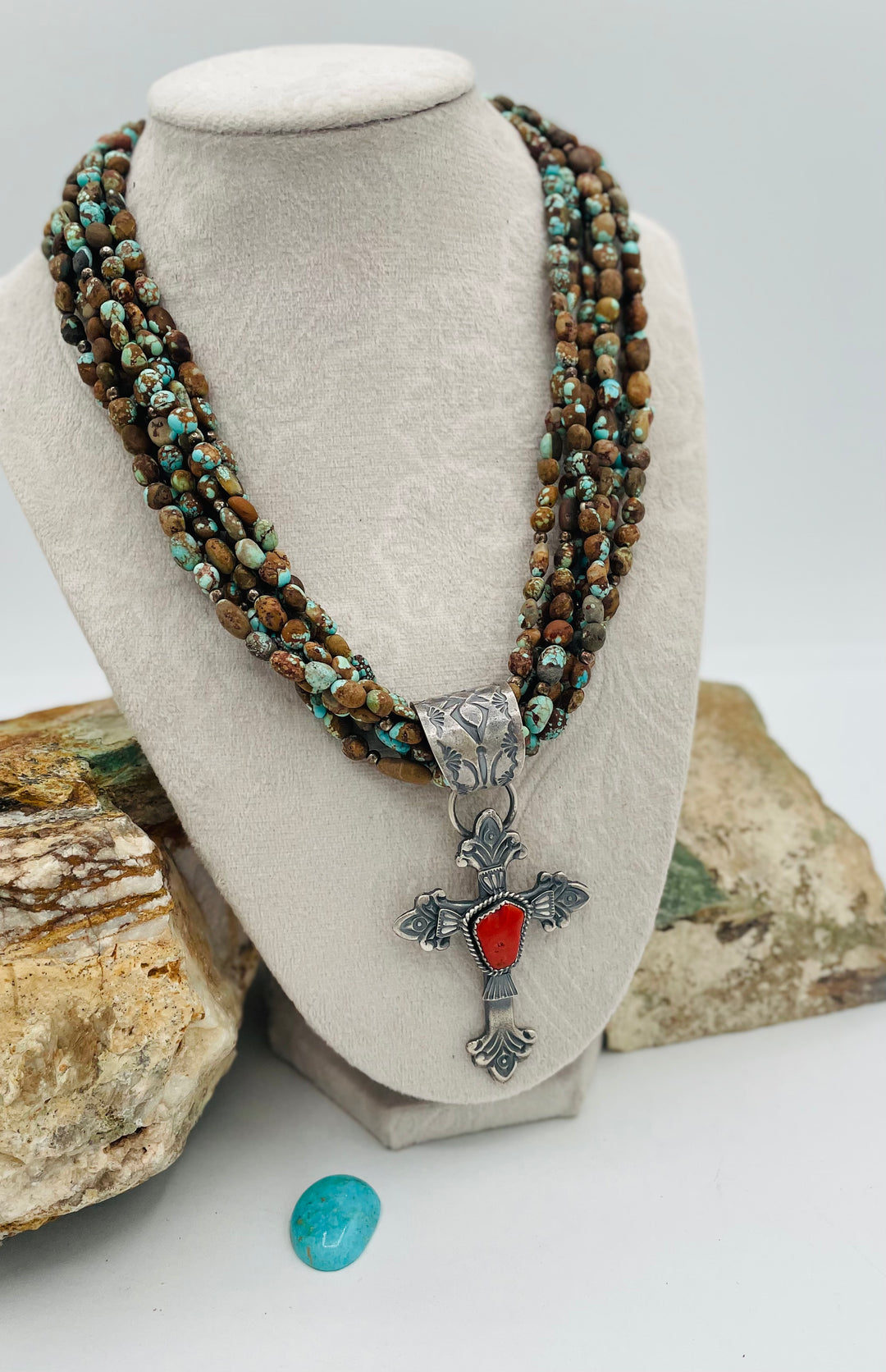 Beaded 7 strand necklace featuring #8 turquoise nuggets, sterling silver beads, with a coral and sterling silver cross pendent. Available only from Rockstar Cowgirl online or in store in Cody, Wyoming.