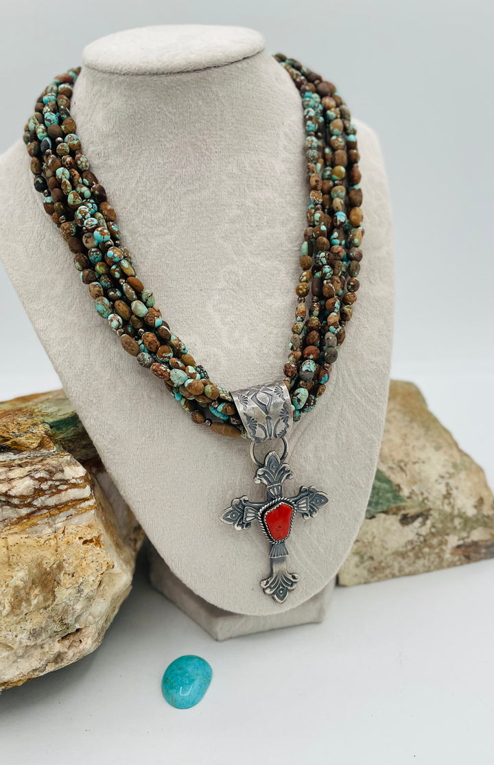 Beaded 7 strand necklace featuring #8 turquoise nuggets, sterling silver beads, with a coral and sterling silver cross pendent. Available only from Rockstar Cowgirl online or in store in Cody, Wyoming.