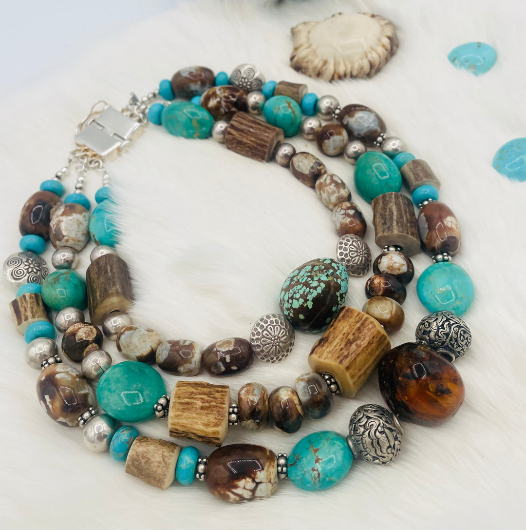 Beaded 3 strand necklace featuring #8 turquoise nuggets, Kingman turquoise nuggets, royal beauty turquoise, crazy lace agate, textured deer antler, and sterling silver beads. Available only from Rockstar Cowgirl online or in store in Cody, Wyoming.
