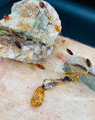 A close up of the amber beads wire wrapped into the vermeil chain as well as the specks in the amber pendant.