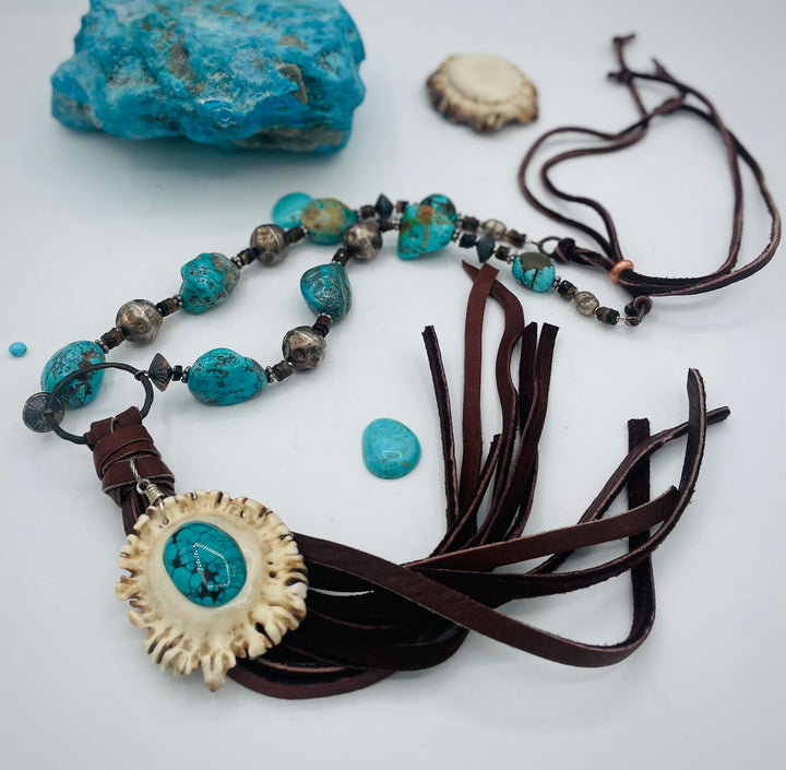 Adjustable beaded necklace featuring Kingman turquoise, hessonite garnet, vintage sterling silver, deer lace tassel with deer antler pendent, and finished with deer lace in the back. Available only from Rockstar Cowgirl online or in store in Cody, Wyoming.