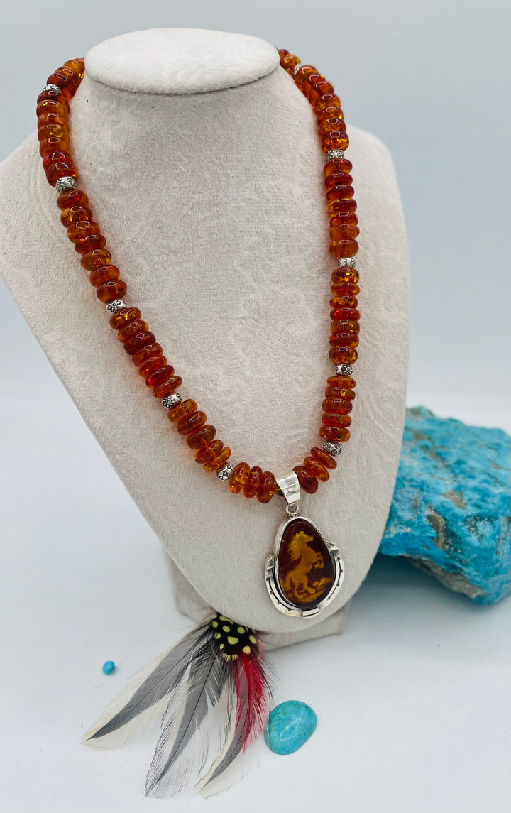 Beaded Baltic amber and sterling silver necklace featuring a Baltic amber and sterling silver pendent with a carved horse reverse cameo. Available only from Rockstar Cowgirl online or in store in Cody, Wyoming.