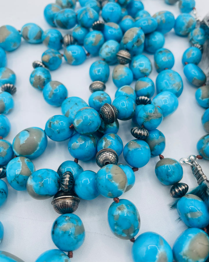 Silk knotted lariat featuring Ithaca peak turquoise, sterling silver beads, and feather tassels. Available only from Rockstar Cowgirl online or in store in Cody, Wyoming.