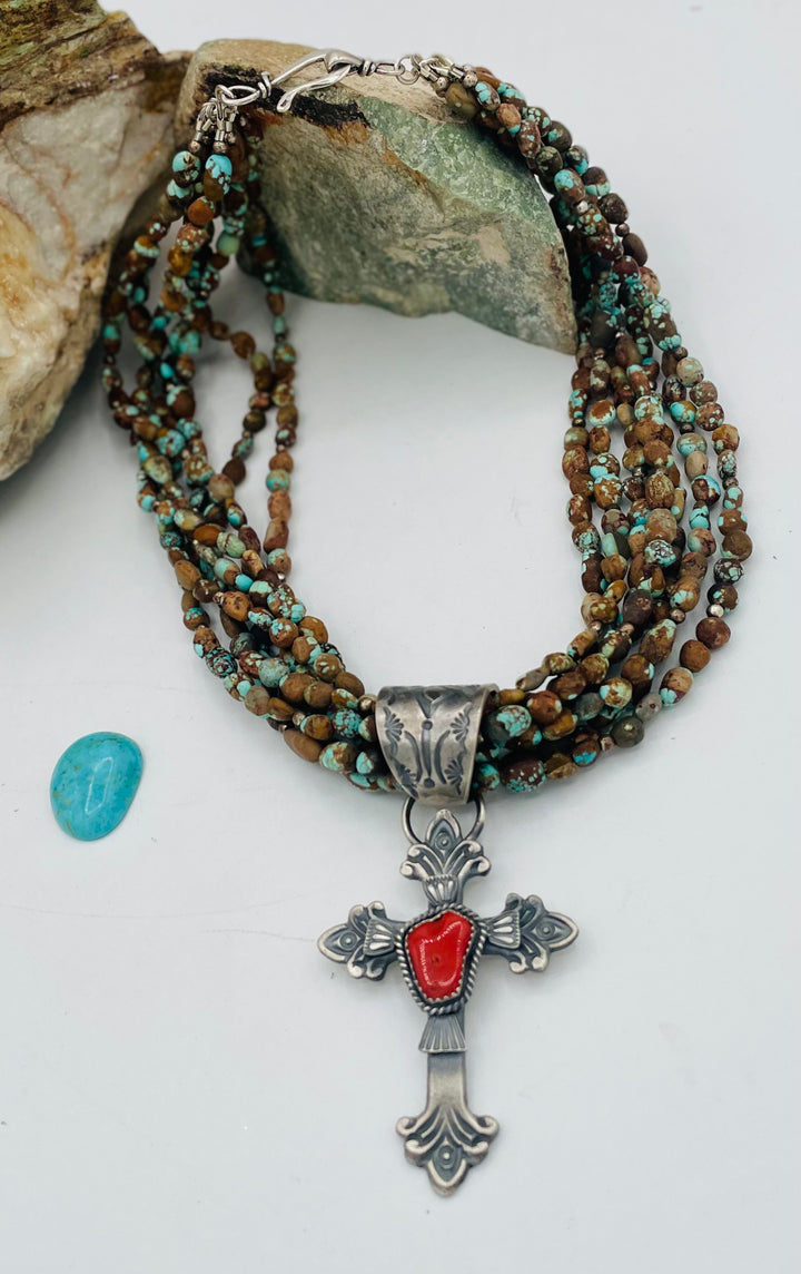 Beaded 7 strand necklace featuring #8 turquoise nuggets, sterling silver beads, with a coral and sterling silver cross pendent. Available only from Rockstar Cowgirl online or in store in Cody, Wyoming.