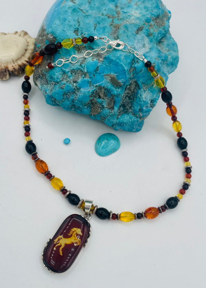 Beaded Baltic amber and sterling silver necklace featuring a Baltic amber and sterling silver pendent with a carved horse reverse cameo. Available only from Rockstar Cowgirl online or in store in Cody, Wyoming.