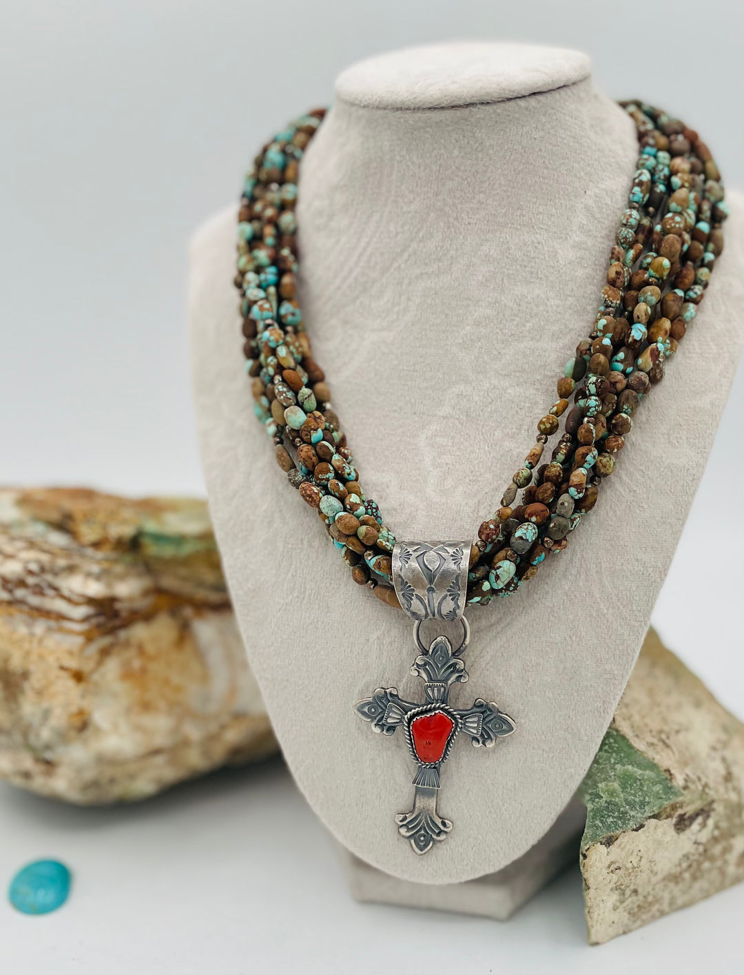 Beaded 7 strand necklace featuring #8 turquoise nuggets, sterling silver beads, with a coral and sterling silver cross pendent. Available only from Rockstar Cowgirl online or in store in Cody, Wyoming.