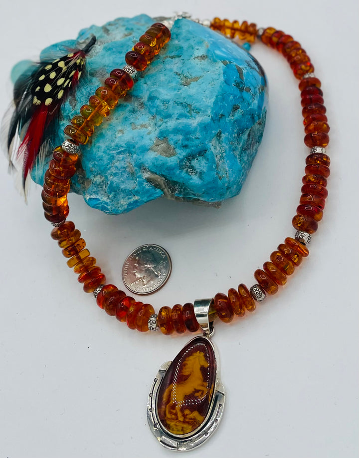 Beaded Baltic amber and sterling silver necklace featuring a Baltic amber and sterling silver pendent with a carved horse reverse cameo. U.S. quarter for size reference. Available only from Rockstar Cowgirl online or in store in Cody, Wyoming.