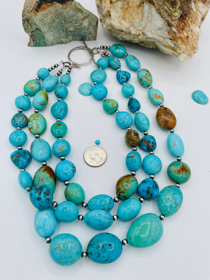 3 strand beaded necklace featuring Kingman turquoise in blues and greens with sterling silver Navajo pearl beads. U. S. quarter for size reference. Available only from Rockstar Cowgirl online or in store in Cody, Wyoming.