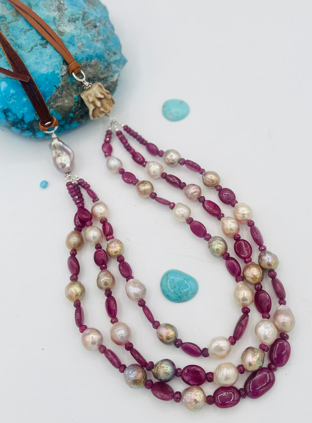 Adjustable 3 strand necklace featuring ruby, Edison pearls, flameball baroque pearl, textured deer antler bead, and finished with deer lace. Available only from Rockstar Cowgirl online or in store in Cody, Wyoming.