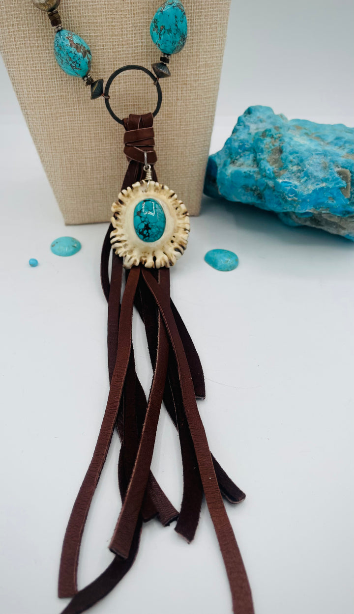 Adjustable beaded necklace featuring Kingman turquoise, hessonite garnet, vintage sterling silver, deer lace tassel with deer antler pendent, and finished with deer lace in the back. Available only from Rockstar Cowgirl online or in store in Cody, Wyoming.