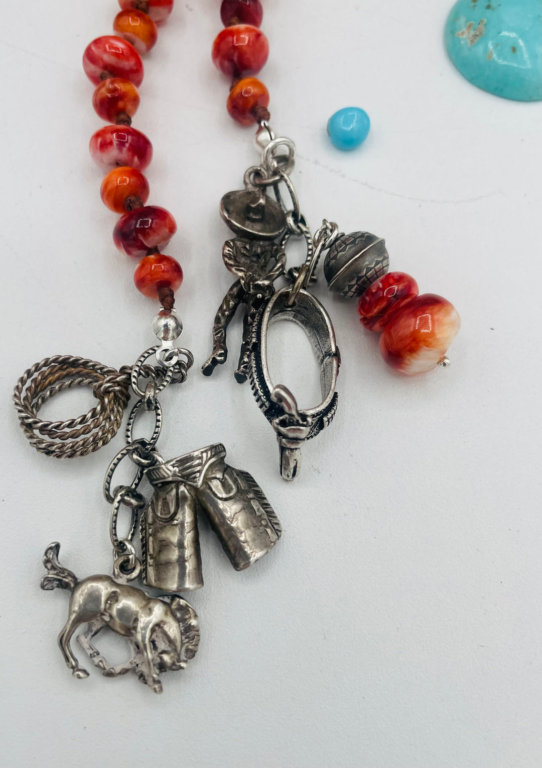 Silk knotted lariat necklace featuring spiney oyster, sterling silver stamped beads, and vintage sterling silver western charms. Available only from Rockstar Cowgirl online or in store in Cody, Wyoming. 