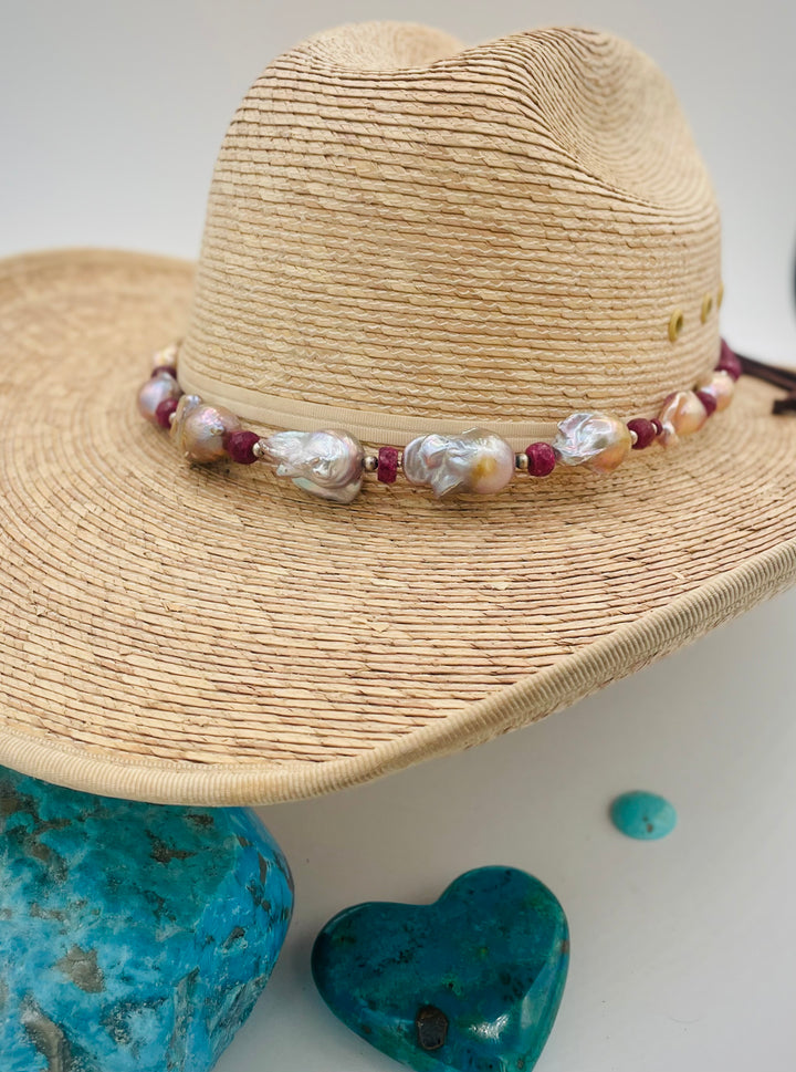 Adjustable beaded hatband featuring flameball natural luster baroque pearls, ruby, sterling silver beads, African silver, and finished with deer lace in the back. Available only from Rockstar Cowgirl online or in store in Cody, Wyoming.
