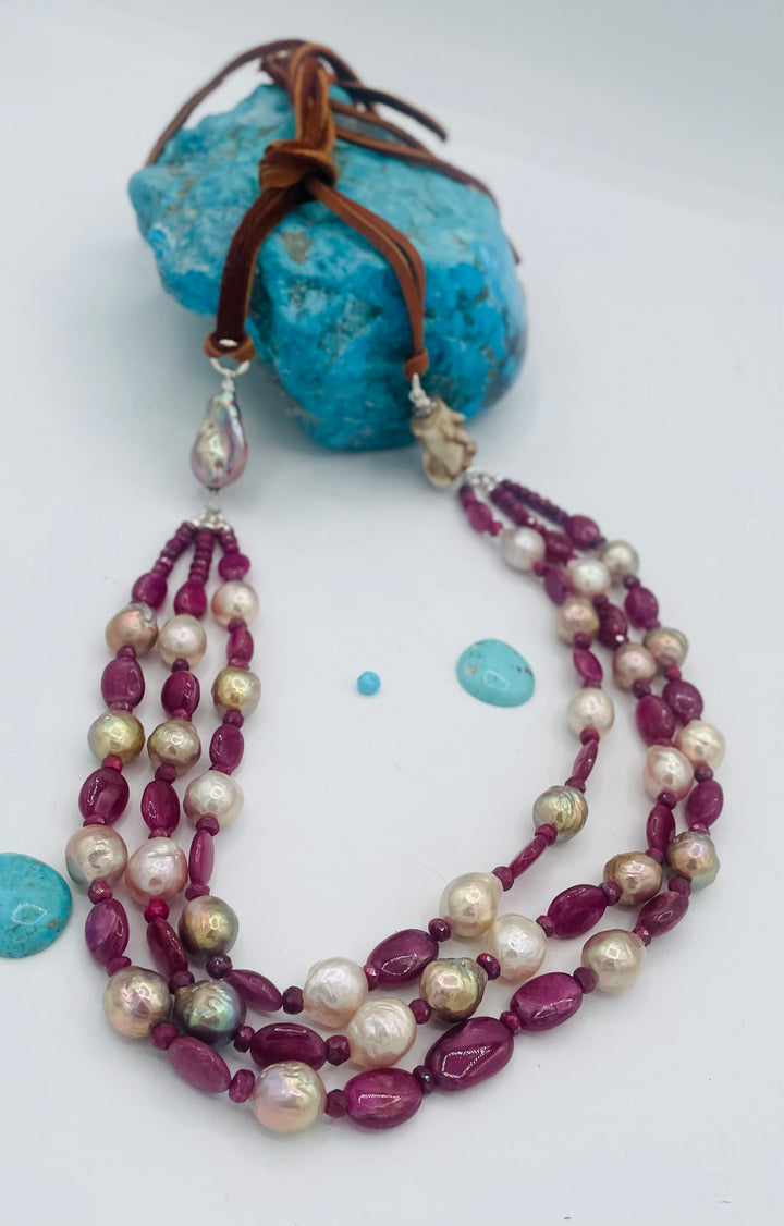 Adjustable 3 strand necklace featuring ruby, Edison pearls, flameball baroque pearl, textured deer antler bead, and finished with deer lace. Available only from Rockstar Cowgirl online or in store in Cody, Wyoming.