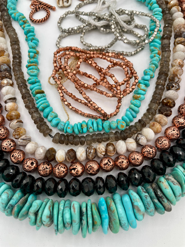 Bead box featuring Campitios and Sonoran turquoise, Australian chrysoprase, spinel, smokey quartz, copper plated lava, with a bone steer pendent. U.S. quarter for size reference. Available only from Rockstar Cowgirl online or in store in Cody, Wyoming.