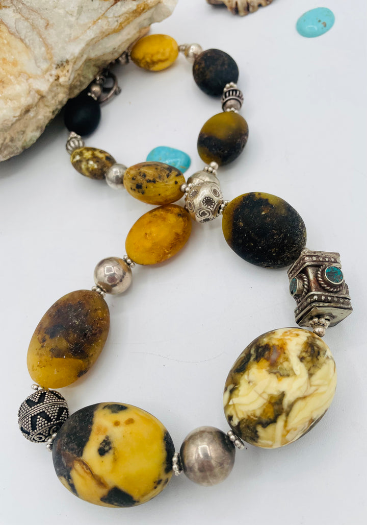 Chunky beaded necklace featuring Baltic amber, repousse beads with turquoise inlay, and sterling silver beads. Available only from Rockstar Cowgirl online or in store in Cody, Wyoming.