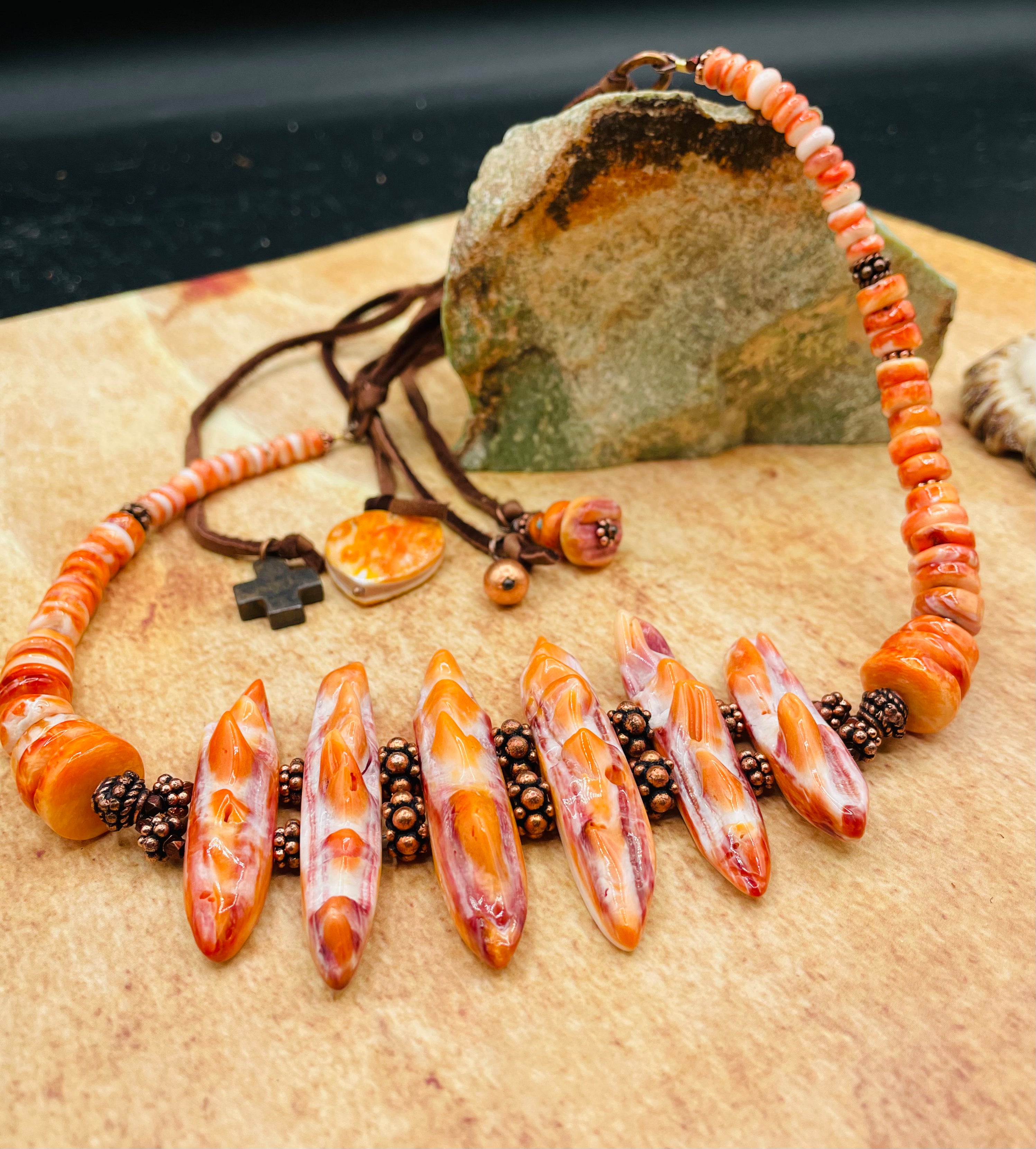 Hatband or necklace featuring several shapes of spiny oyster beads and copper accents. Finished with deer lace each with a charm and a slide bead for fit. Available only from Rockstar Cowgirl online or in store in Cody, Wyoming.