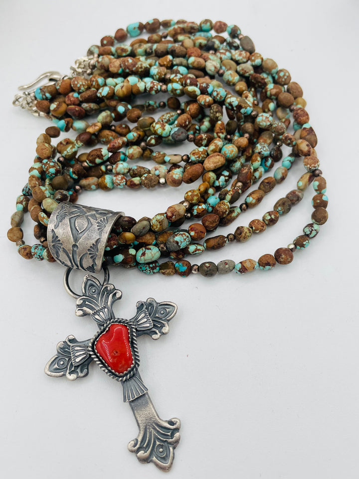Beaded 7 strand necklace featuring #8 turquoise nuggets, sterling silver beads, with a coral and sterling silver cross pendent. Available only from Rockstar Cowgirl online or in store in Cody, Wyoming.