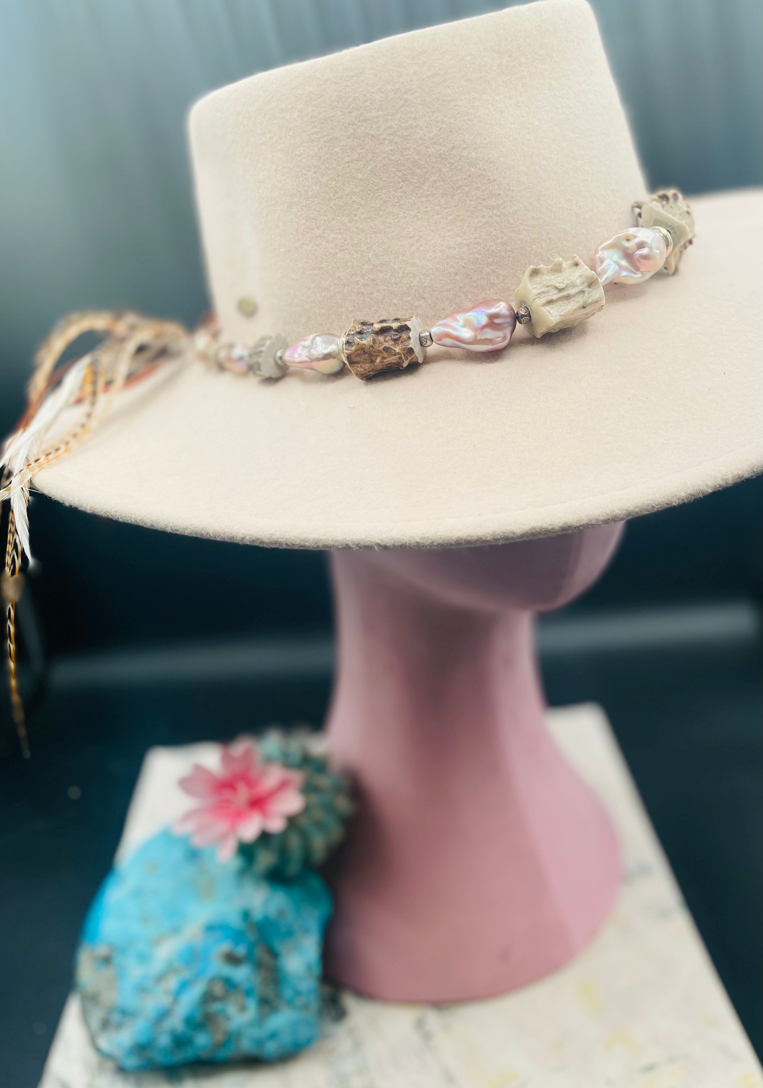 Hatband or necklace with giant baroque natural luster pearls, knobby deer antler beads, and  sterling silver beads and finished with feathers, deer lace, and a slide bead. Available only from Rockstar Cowgirl online or in store in Cody, Wyoming.