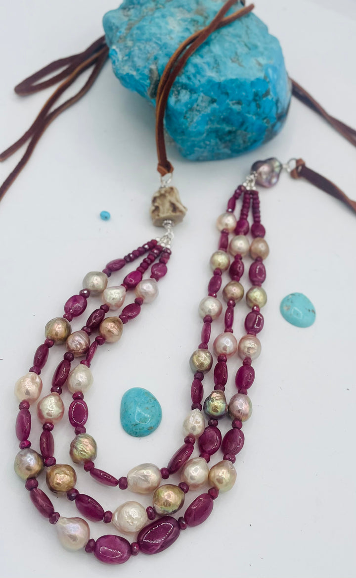 Adjustable 3 strand necklace featuring ruby, Edison pearls, flameball baroque pearl, textured deer antler bead, and finished with deer lace. Available only from Rockstar Cowgirl online or in store in Cody, Wyoming.