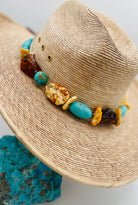 Adjustable beaded hatband featuring Kingman turquoise, Baltic amber, and sterling silver Navajo pearl beads and finished with deer leather and a silicone slide bead. Available only from Rockstar Cowgirl online or in store in Cody, Wyoming.