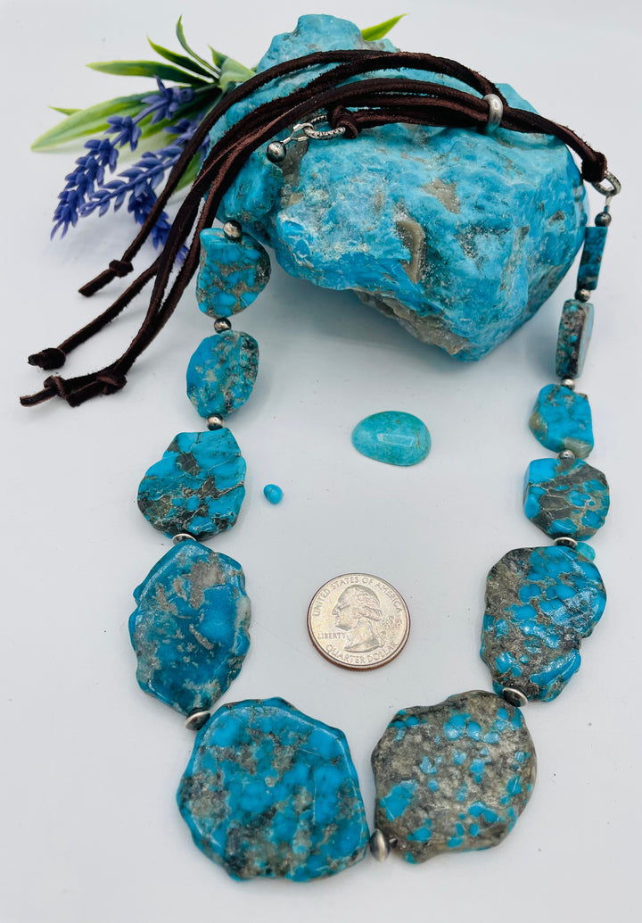 Beaded adjustable hatband that doubles as a necklace featuring Ithaca Peak turquoise and sterling silver Navajo pearl beads with deer lace in the back. U.S. quarter for size reference. Available only from Rockstar Cowgirl online or in store in Cody, Wyoming. 