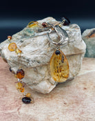 A close up of the vermeil chain, bronze toggle and amber pendant.