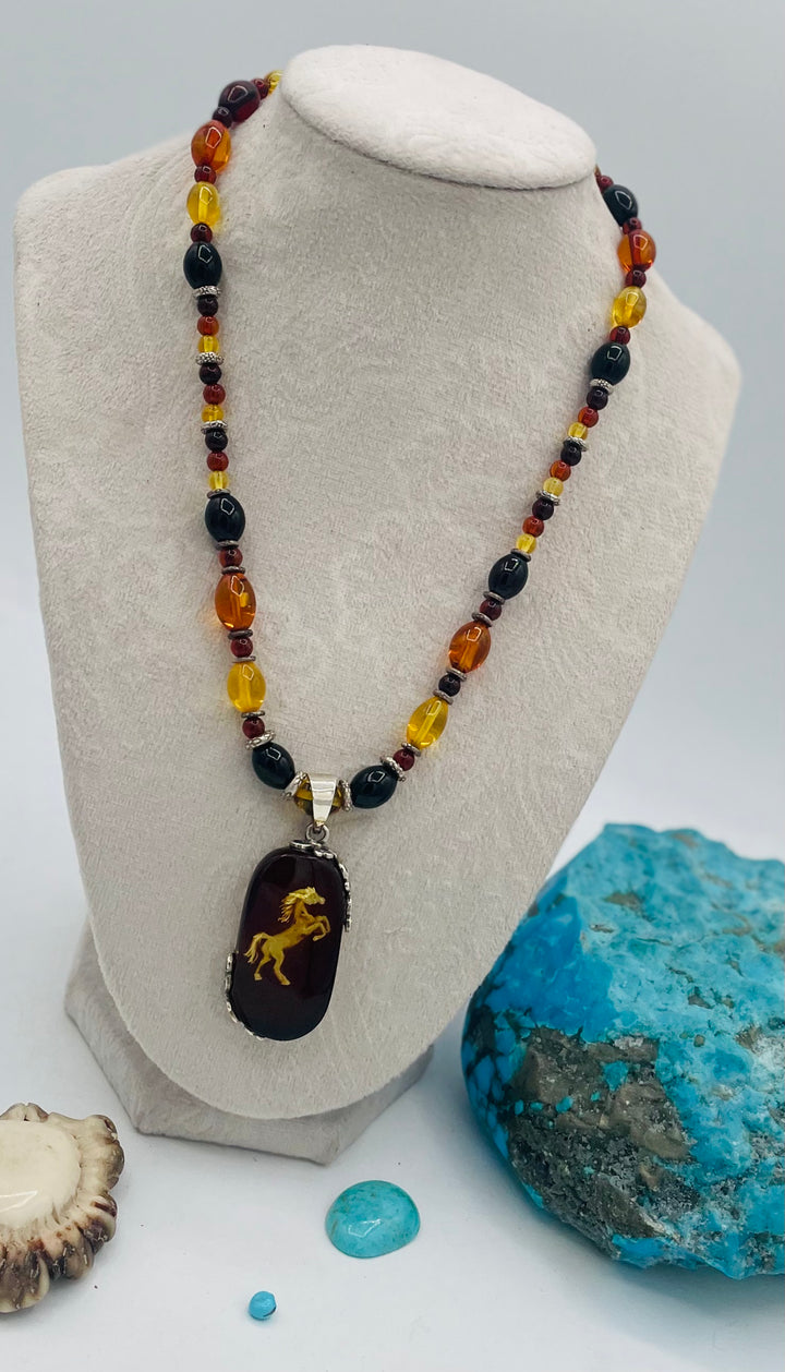 Beaded Baltic amber and sterling silver necklace featuring a Baltic amber and sterling silver pendent with a carved horse reverse cameo. Available only from Rockstar Cowgirl online or in store in Cody, Wyoming.