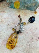 Close up of the front facing bronze toggle clasp and amber pendant.