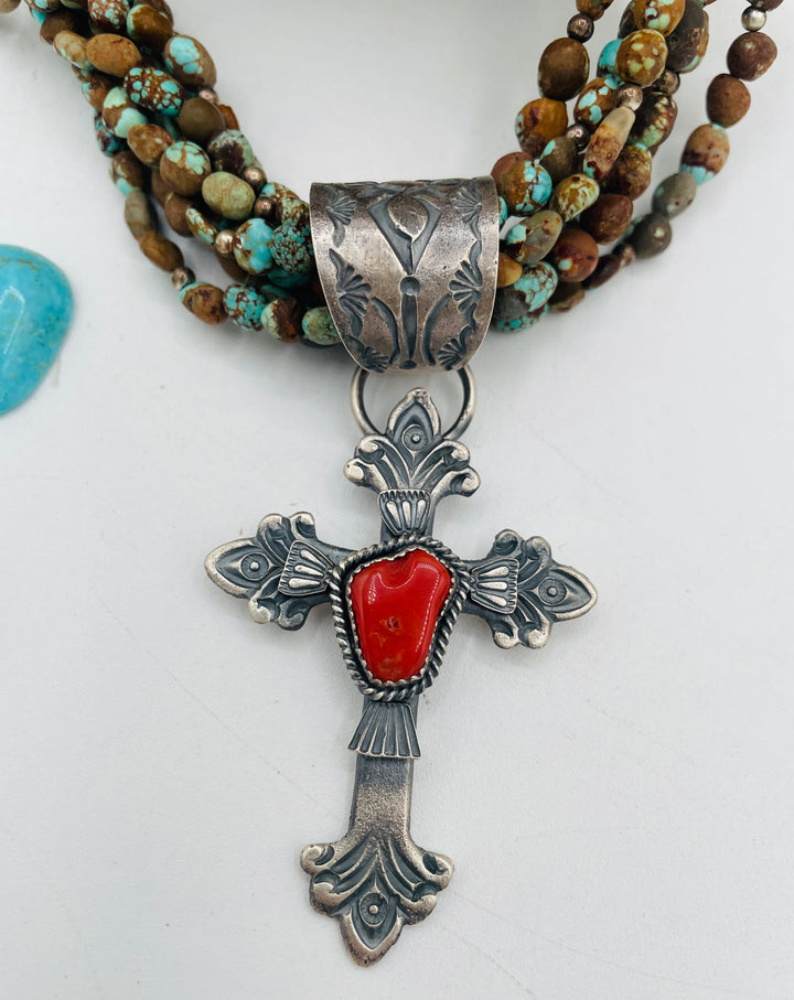 Beaded 7 strand necklace featuring #8 turquoise nuggets, sterling silver beads, with a coral and sterling silver cross pendent. Available only from Rockstar Cowgirl online or in store in Cody, Wyoming.