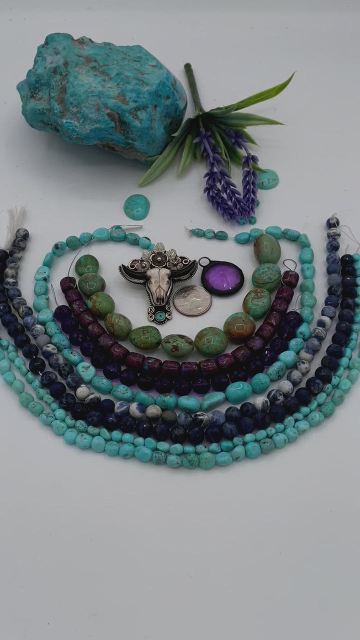 Bead box featuring Sonoran turquoise, sodalite, fruity purple turquoise, green Kingman turquoise nuggets, amethyst, steer pendent and crystal charm. U.S. Quarter for size reference. Available only from Rockstar Cowgirl online or in store in Cody, Wyoming. 
